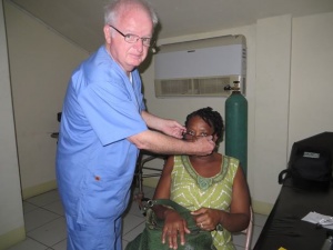 Dr Chambers putting glasses on a woman